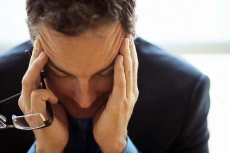 Businessman Holding Head in Hands --- Image by ©LWA-Stephen Welstead/CORBIS